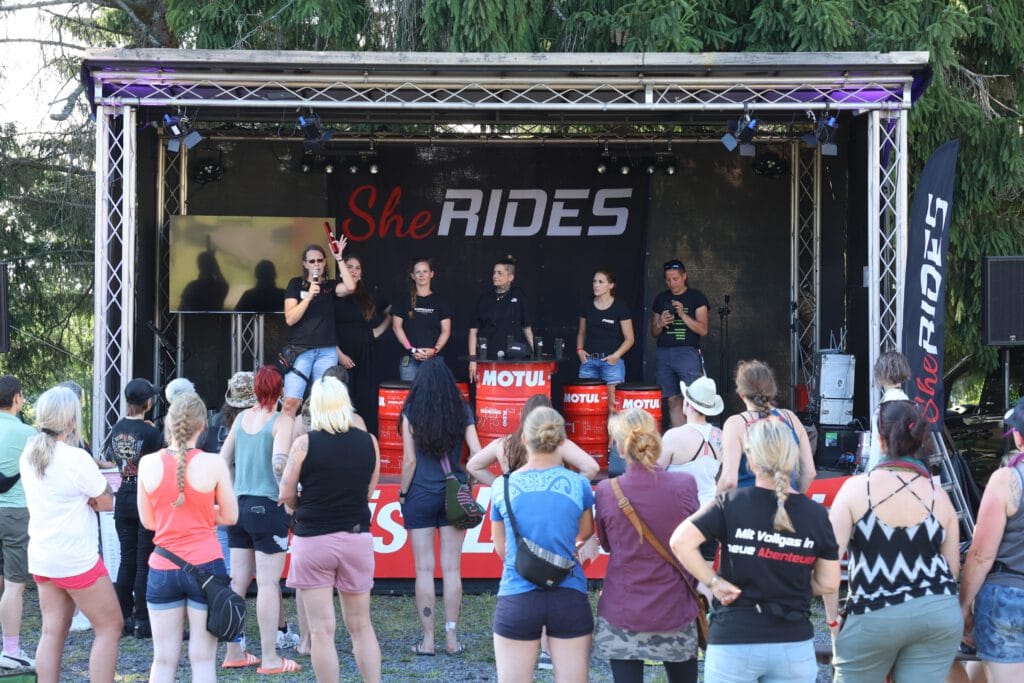 Start der Staffelfahrt beim SHE RIDES Summit 2025. Empfang des Staffelstabs auf der Bühne.