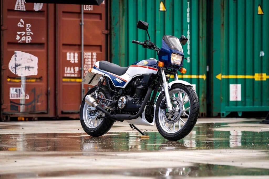 Honda GB350S blau weiß rot schräg vor Containern