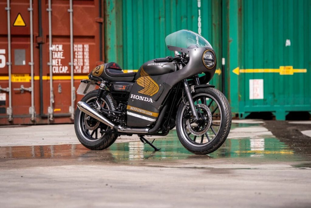 Honda GB350S schwarz gold schräg vor Containern