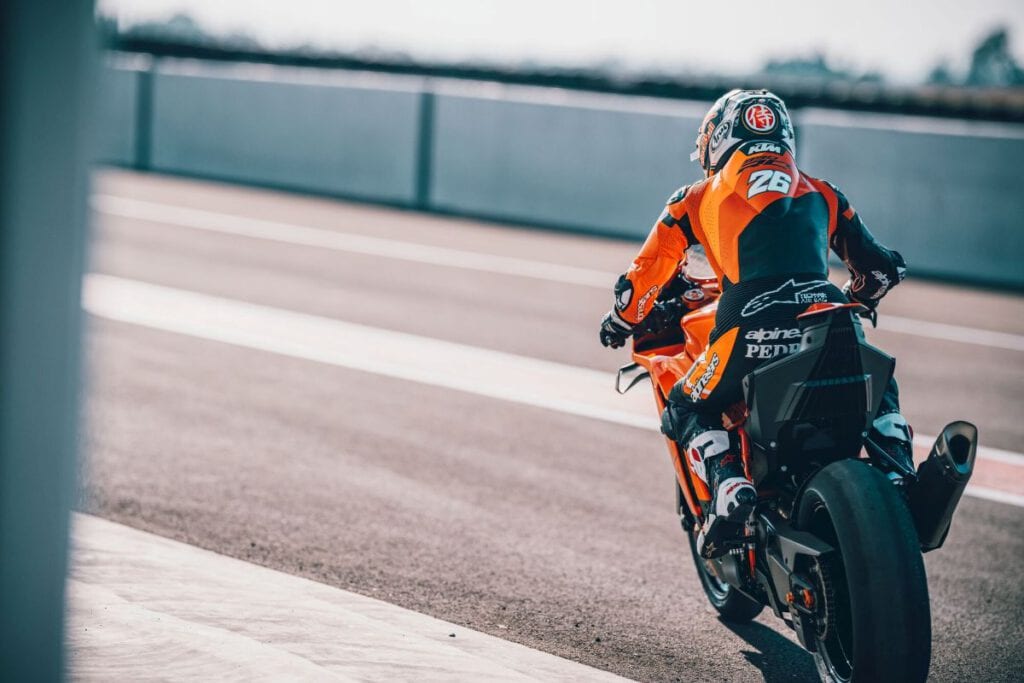KTM 990 RC R 2026 – Supersportlicher Adrenalinträger für Straße und Rennstrecke 3 KTM 990 RC R 2026 Fahrer auf der Rennstrecke von hinten