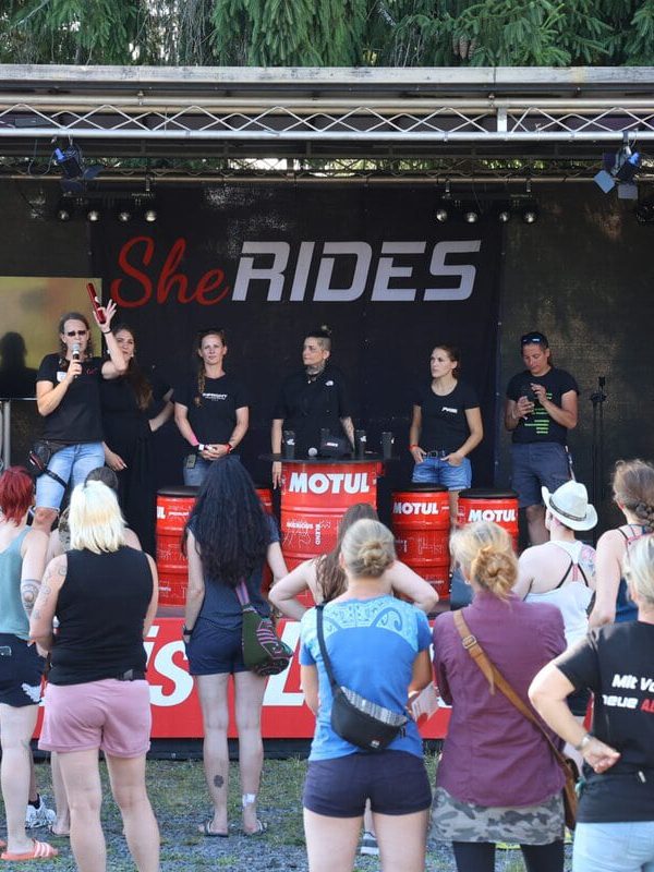 Start der Staffelfahrt beim SHE RIDES Summit 2025. Empfang des Staffelstabs auf der Bühne.